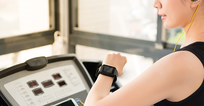 Active8me How Long Should a HIIT Workout Be? Woman on treadmill looking at watch